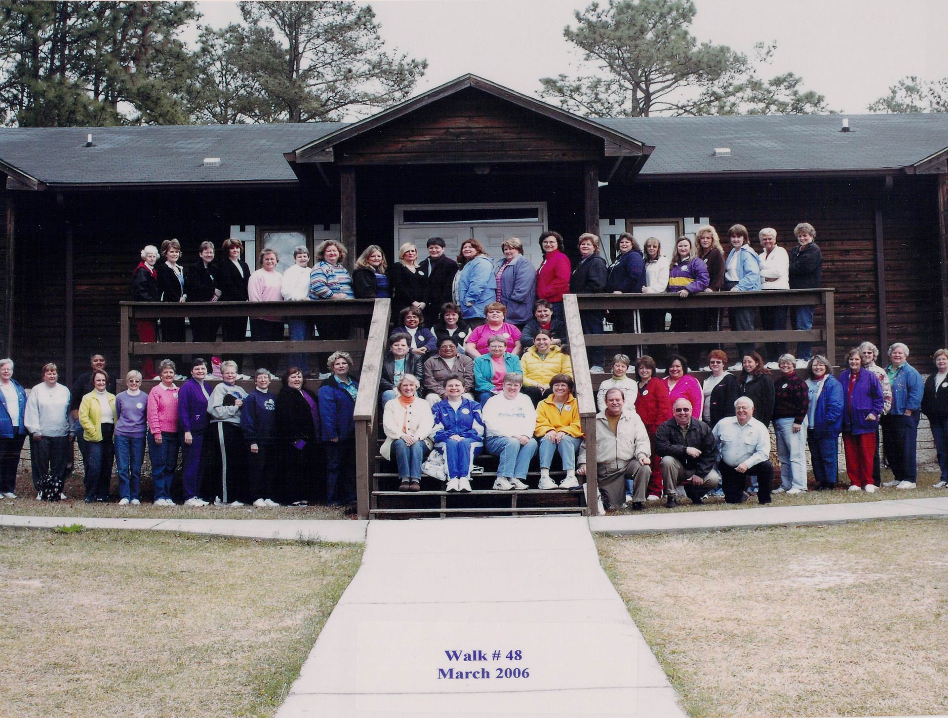 A group of people are posing for a picture in front of a building that says week 18