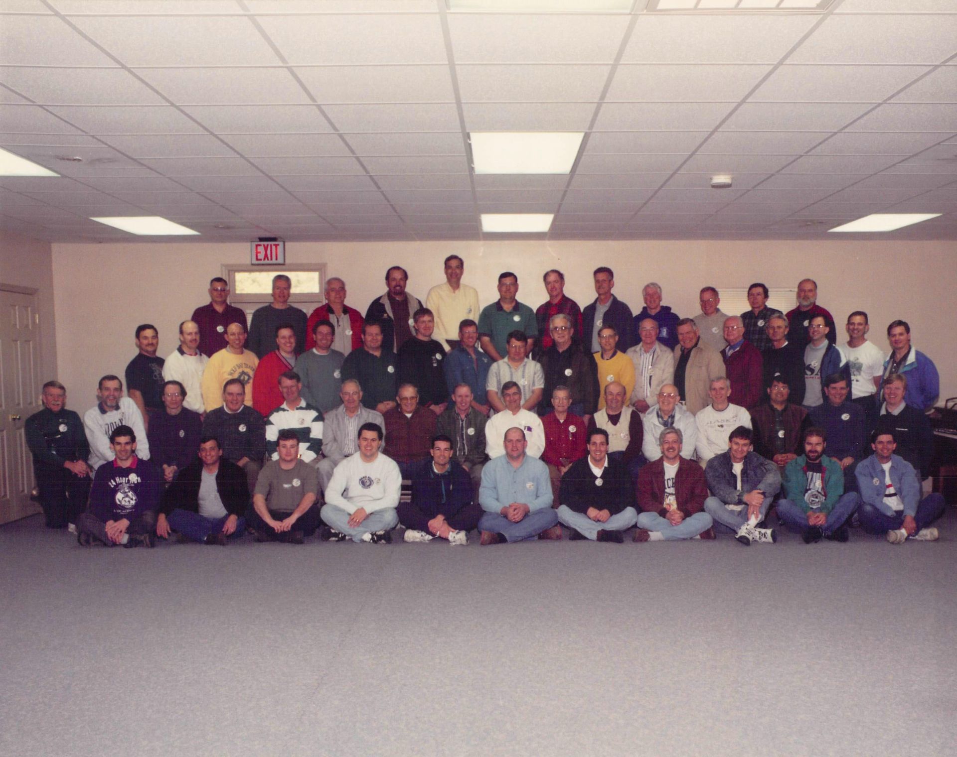 A large group of people are posing for a picture in a room