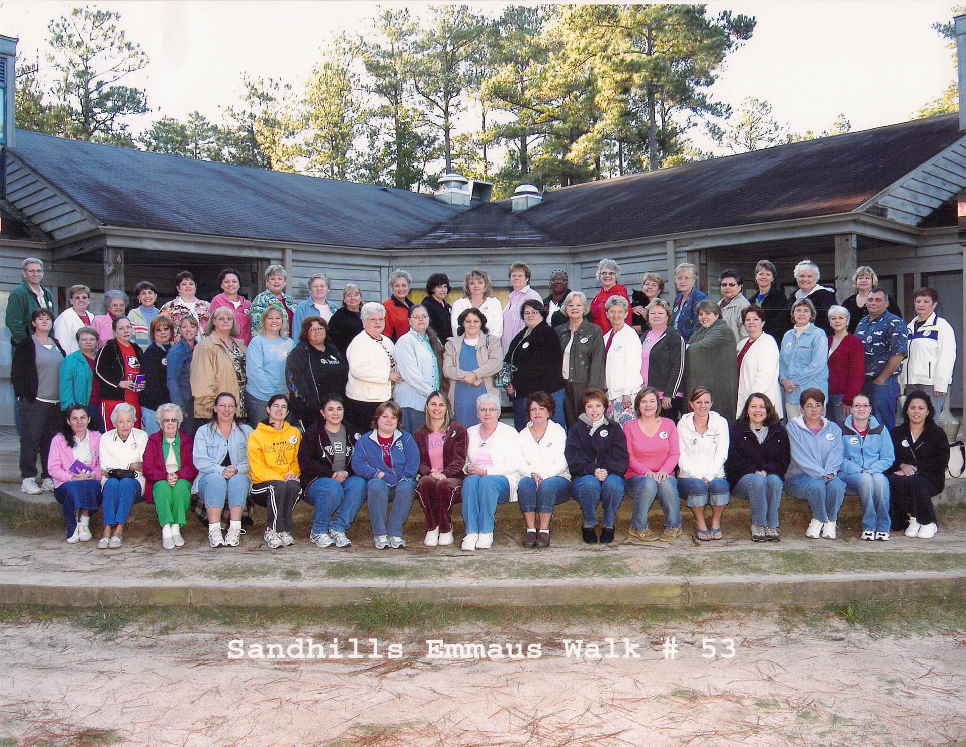 A large group of people are posing for a picture in front of a building