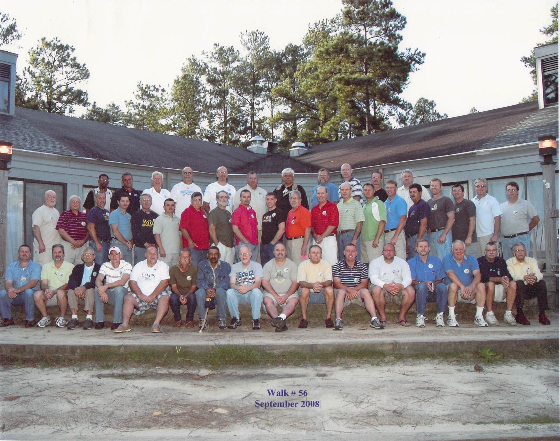 A group of men are posing for a picture in front of a building