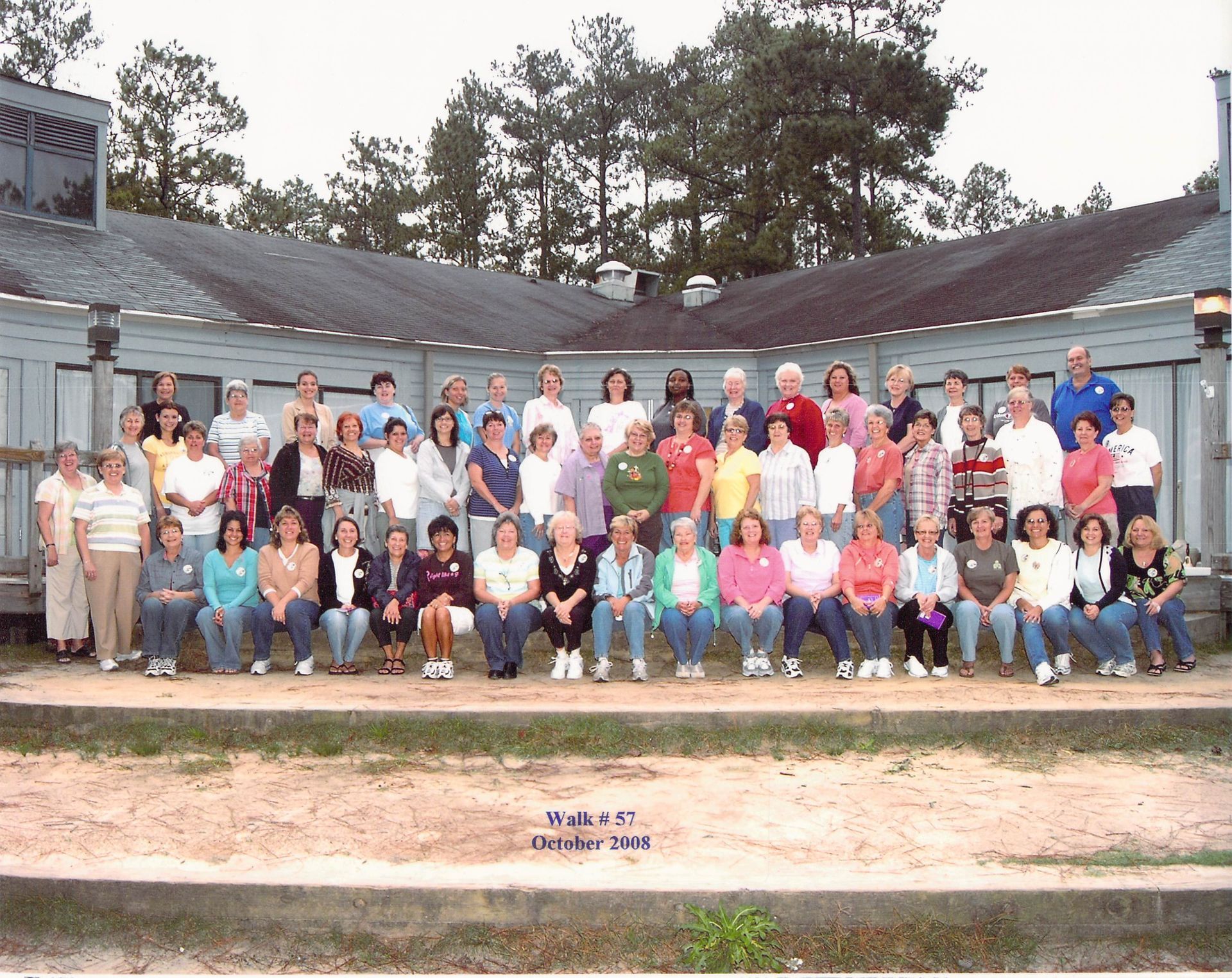 A large group of people are posing for a picture in front of a building