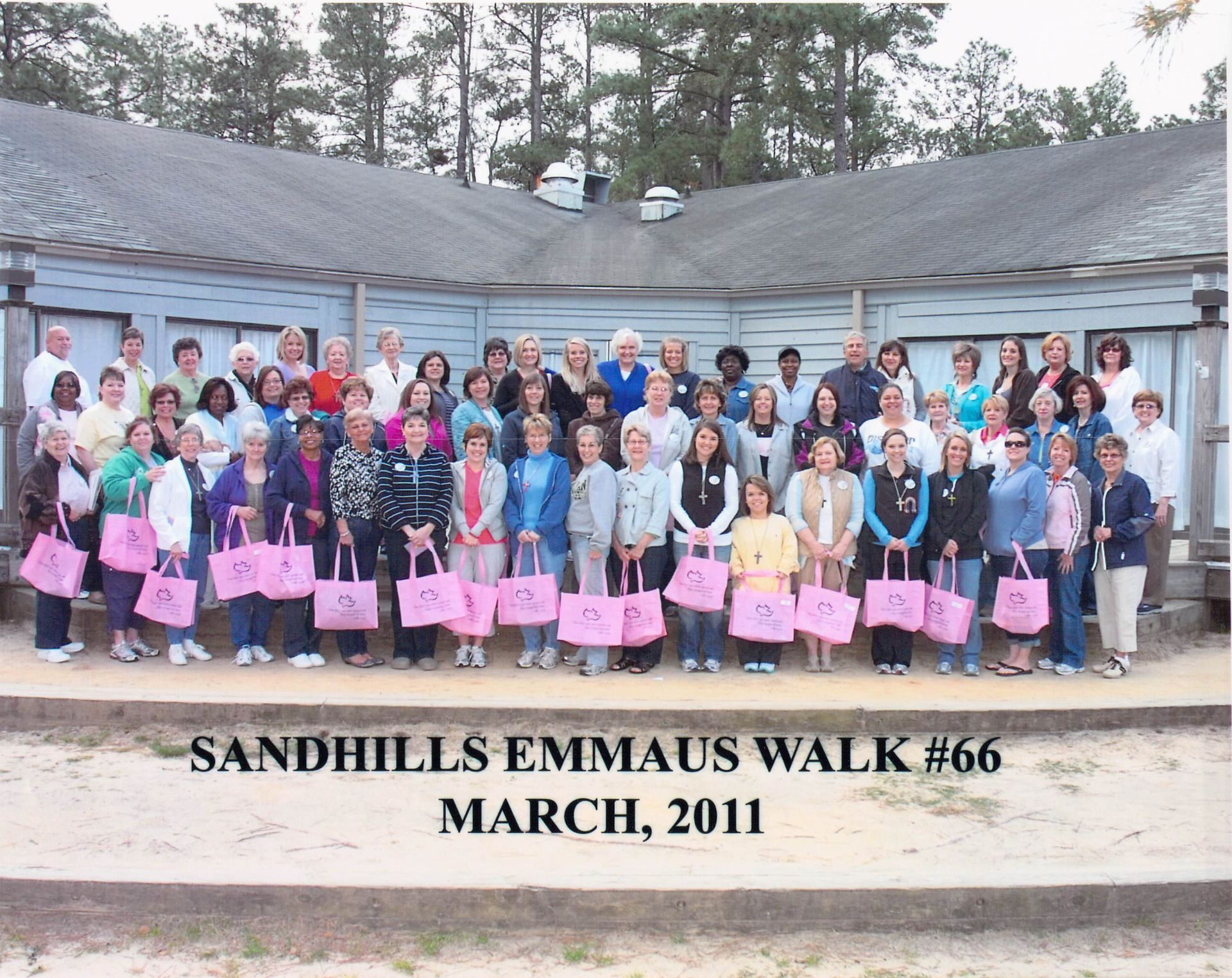 A group of people standing in front of a building that says sandhills emmaus walk # 66 march 2011