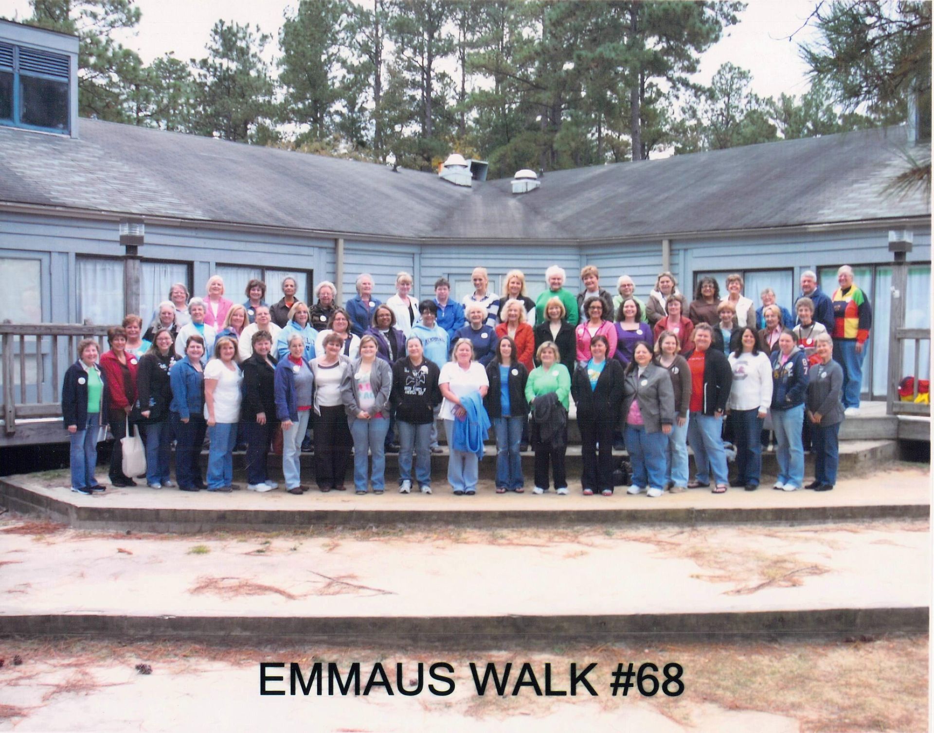A group of people standing in front of a building with the words emmaus walk # 68 on the bottom