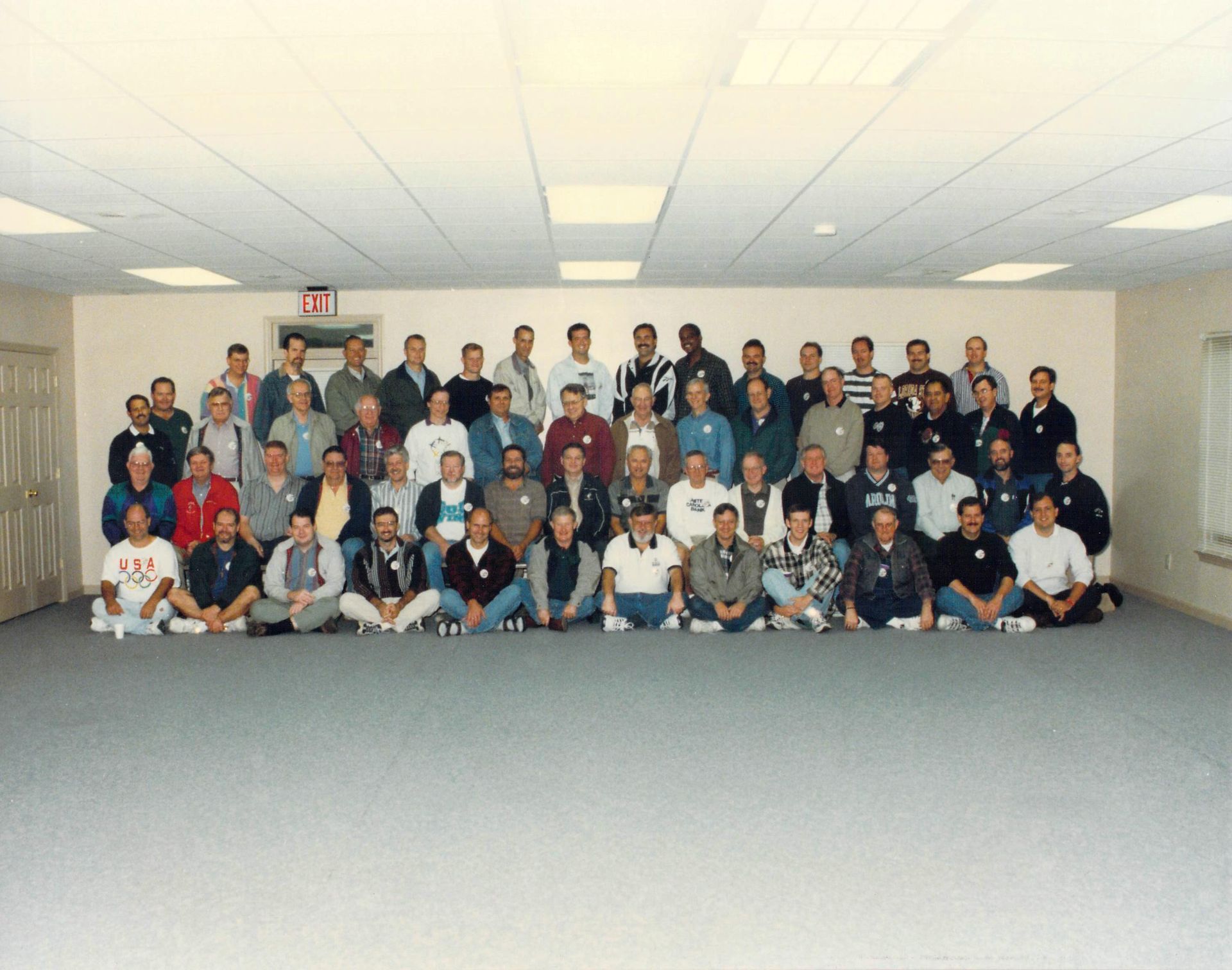 A large group of people are posing for a picture in a room