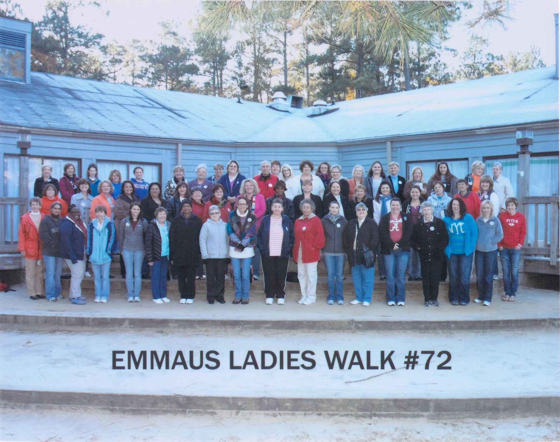 A group of people standing in front of a sign that says emmaus ladies walk # 72