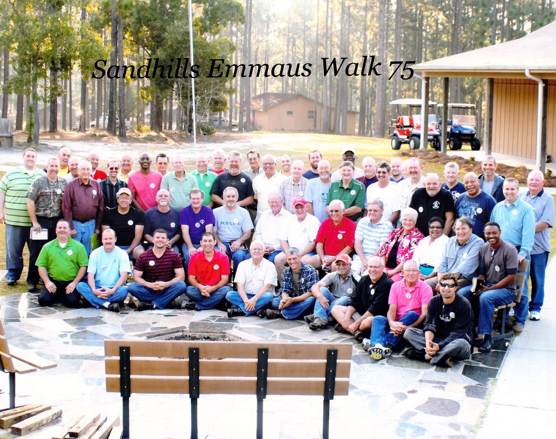 A group of men are posing for a photo at sandhills emmaus walk 75