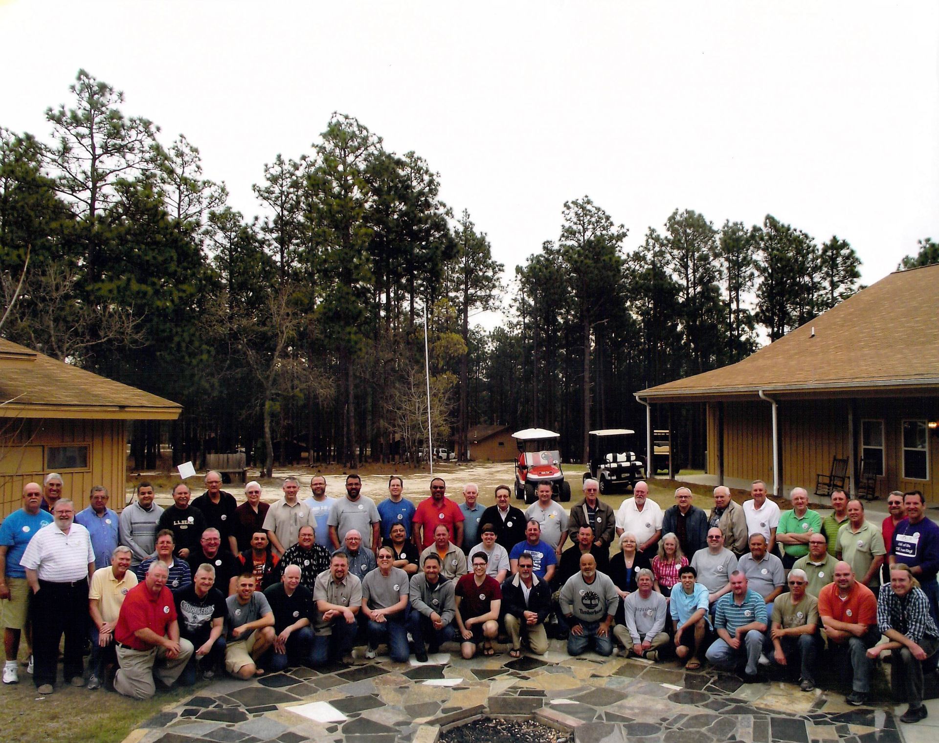 A group of men are posing for a picture in front of a house