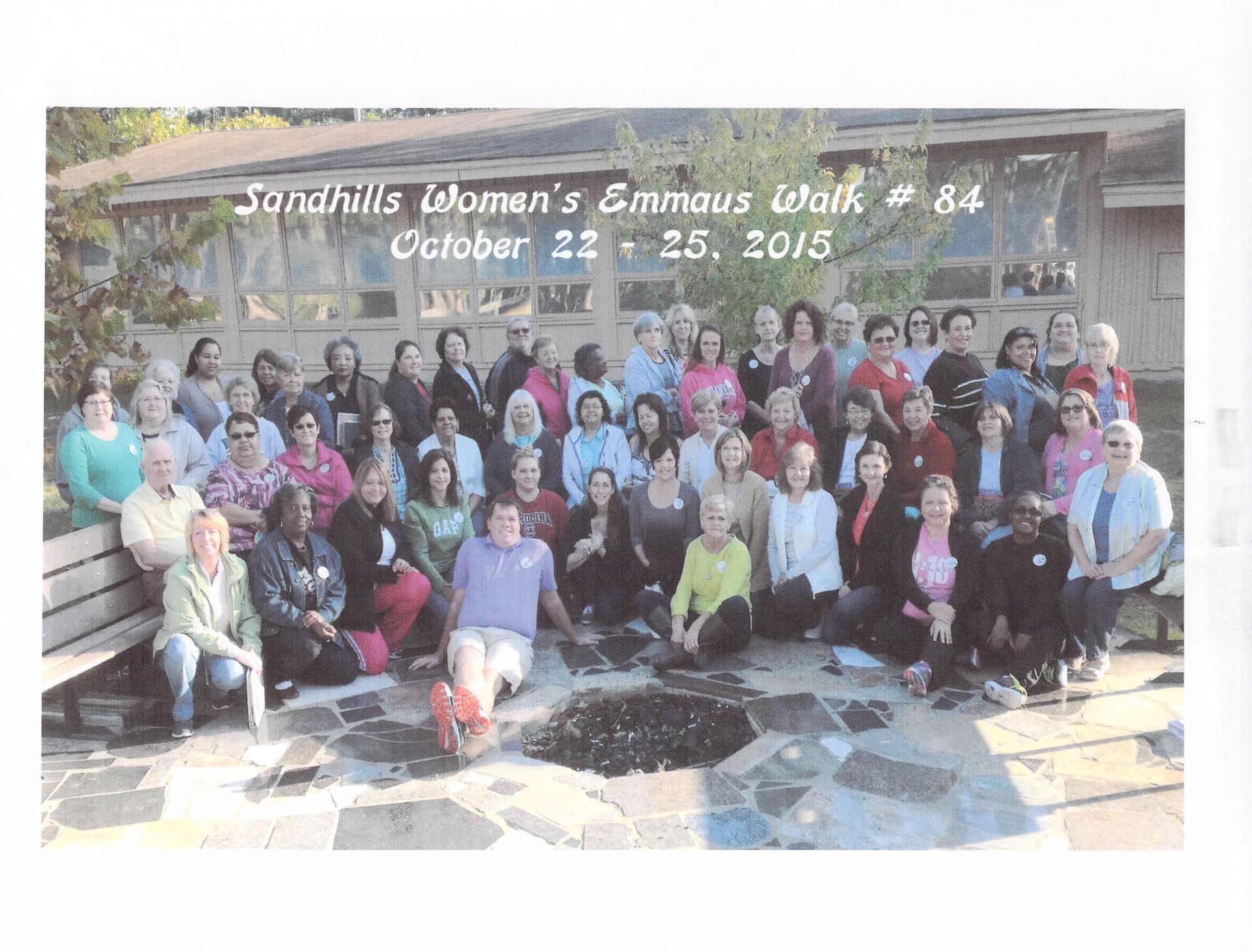 A group of people are posing for a photo at sandhills women 's emmanuel walk # 84