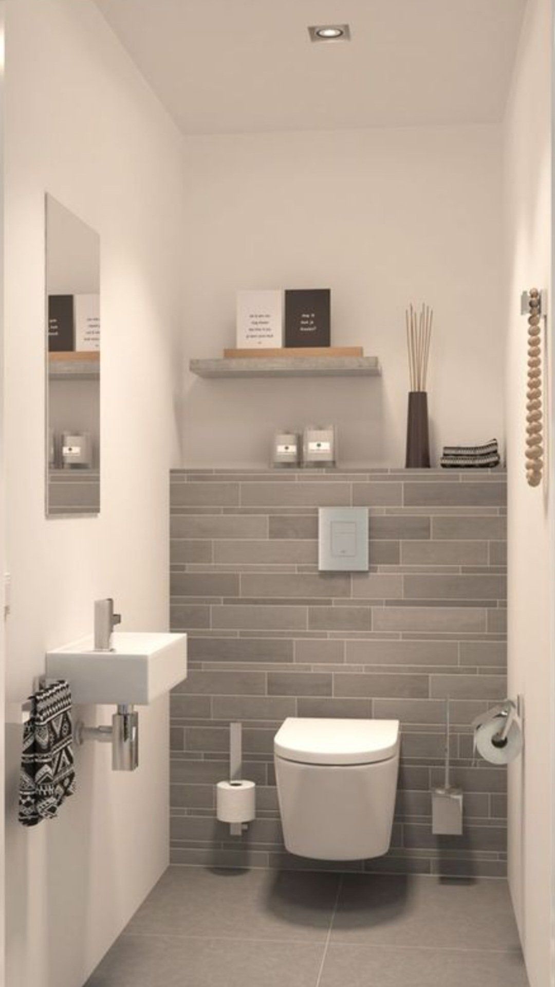 Kleine, moderne badkamer met grijze tegelmuur, wit toilet en wastafel.