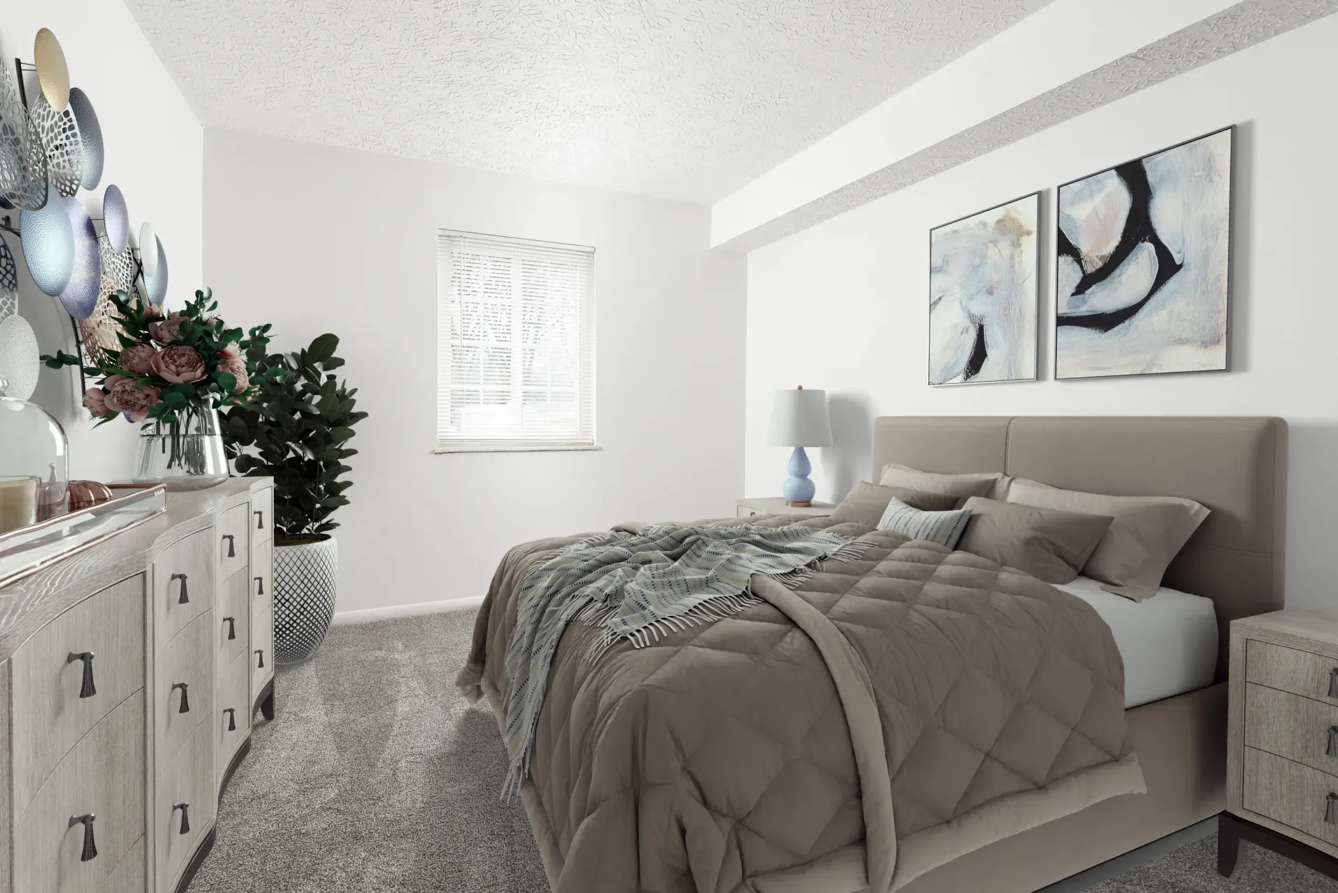 Bedroom interior in a modern apartment with a large bed, dressers, plants, and abstract wall art.