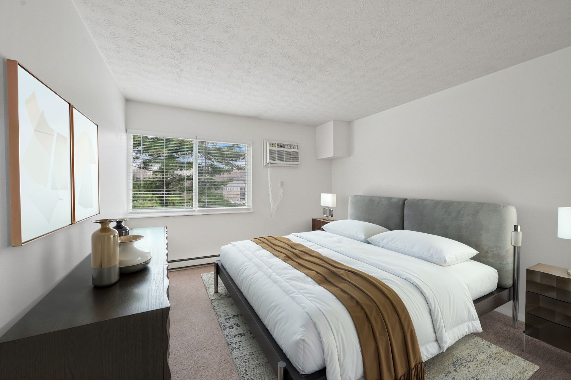 Bedroom with a large bed, two nightstands, dresser, and window with blinds.