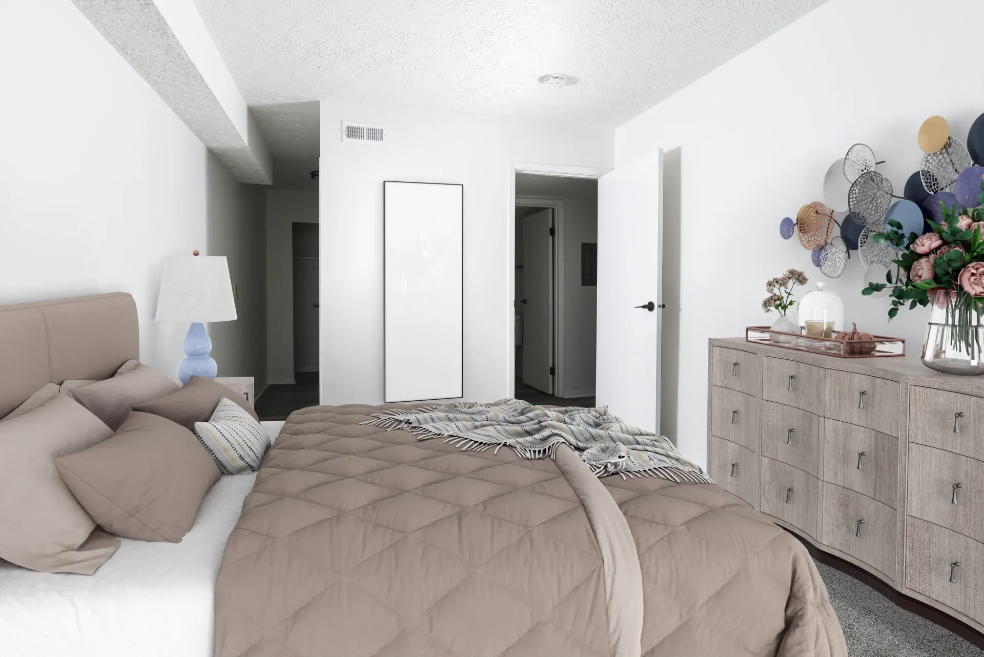 Modern bedroom with beige bed, matching pillows, a large dresser, and an open door to a hallway.