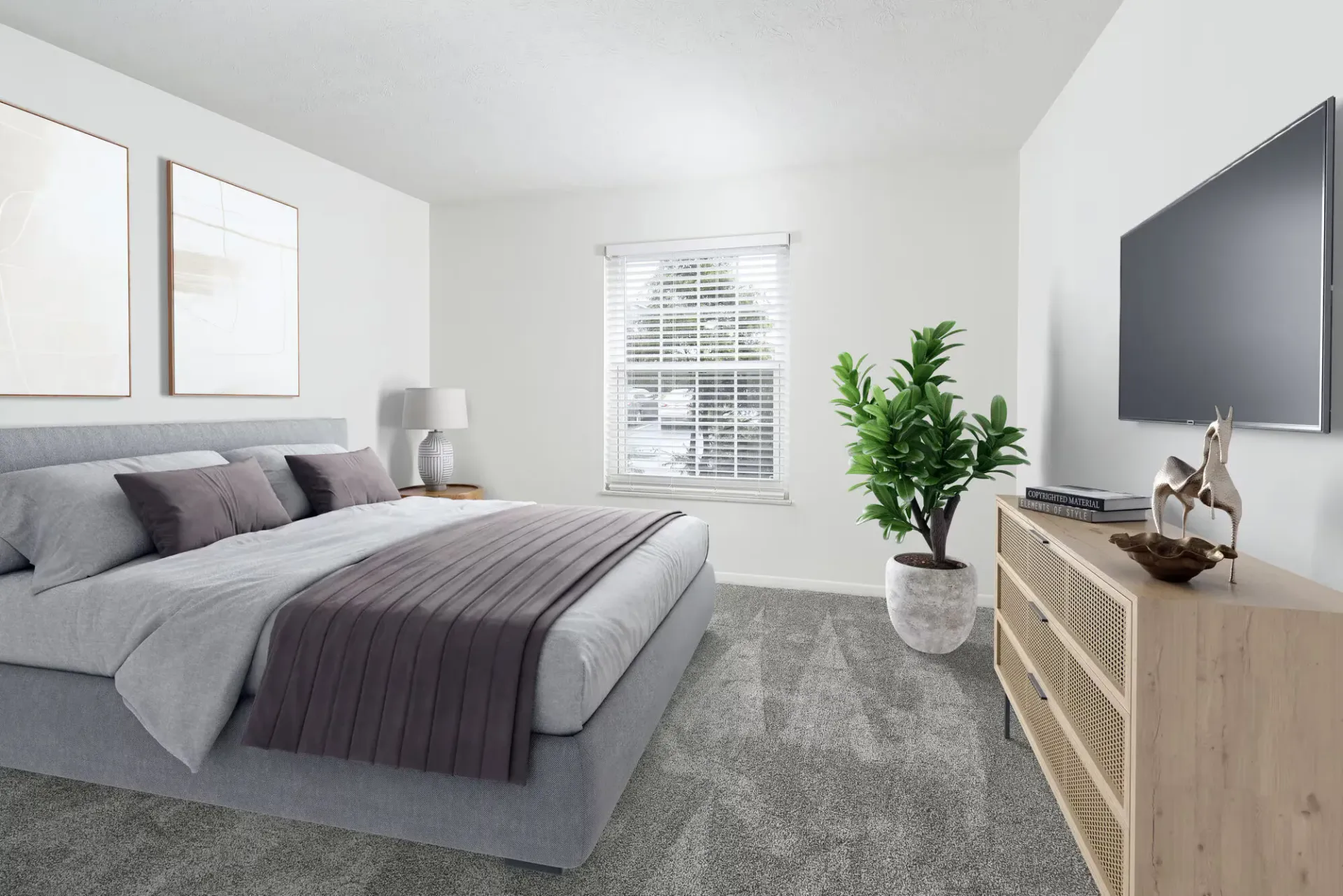 Furnished bedroom with gray upholstered bed, nightstand, window, dresser, TV, and plant.