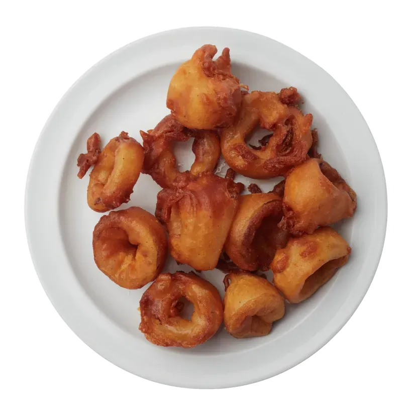 Plate of golden-brown onion rings, fried and circular, on a white plate.