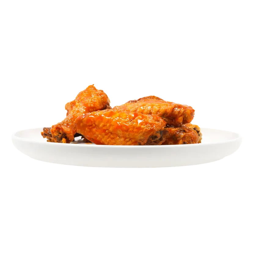 Chicken wings on a white plate. Crispy, orange-colored wings.