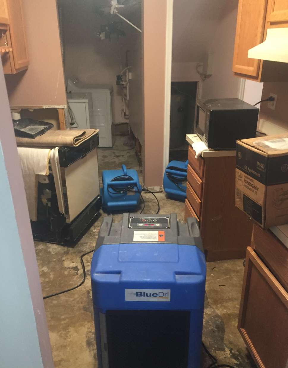 An unfinished attic space under construction with exposed wooden beams, white walls, and floor-mounted electrical conduits.