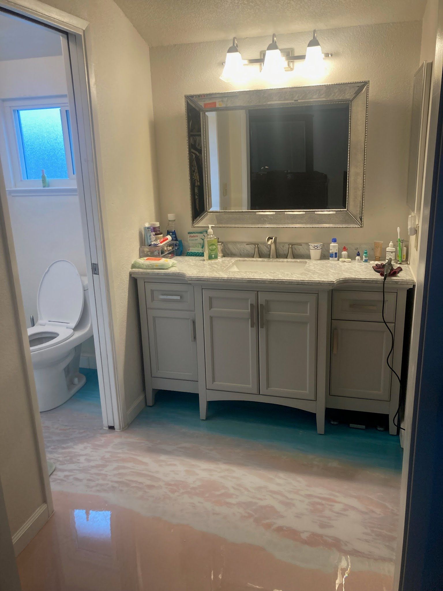 A bathroom with two sinks a toilet and a mirror