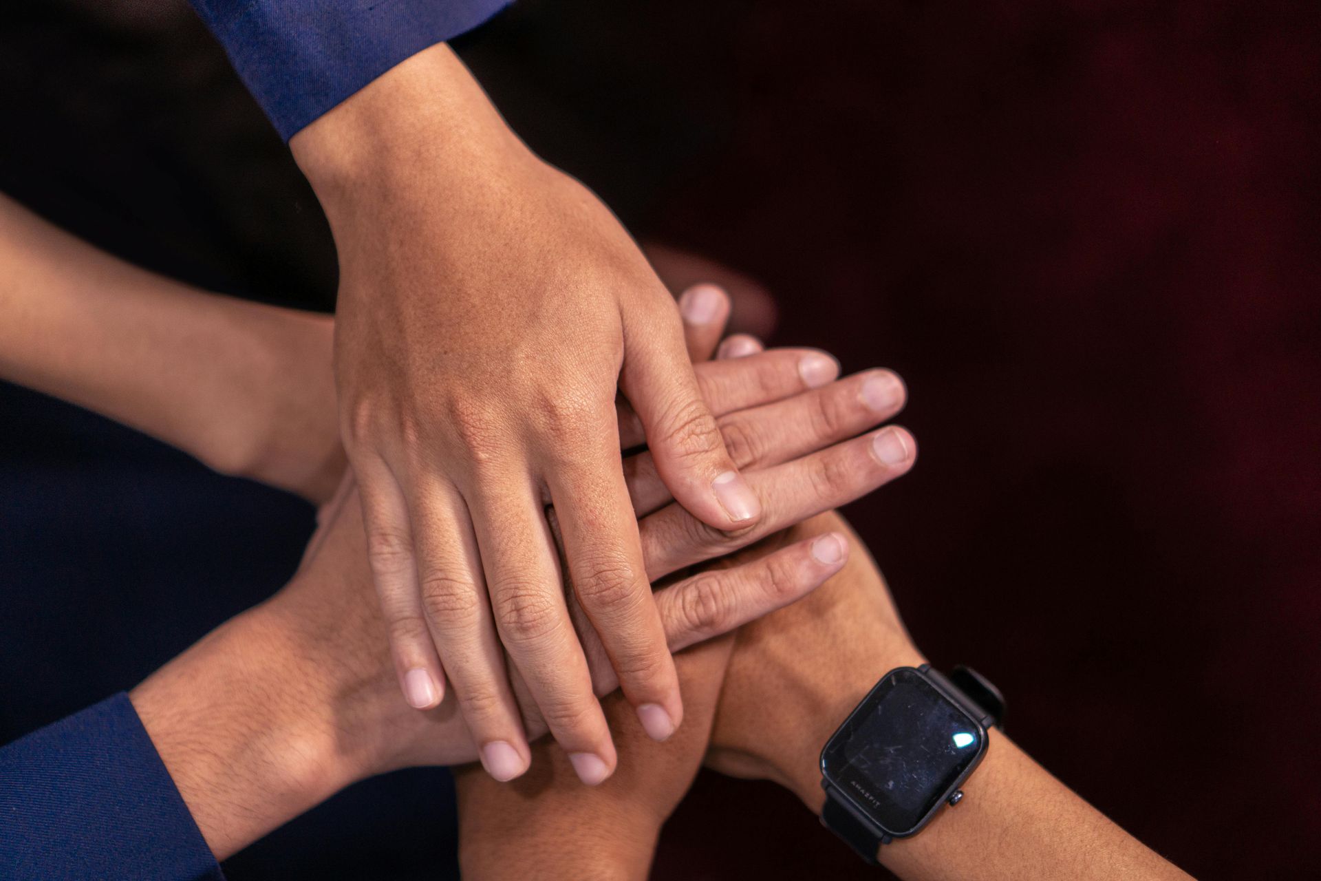 A group of people are putting their hands together