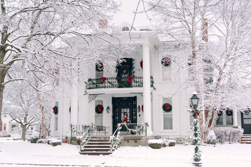 Family of four laughing together on grass in a park, enjoying quality time.