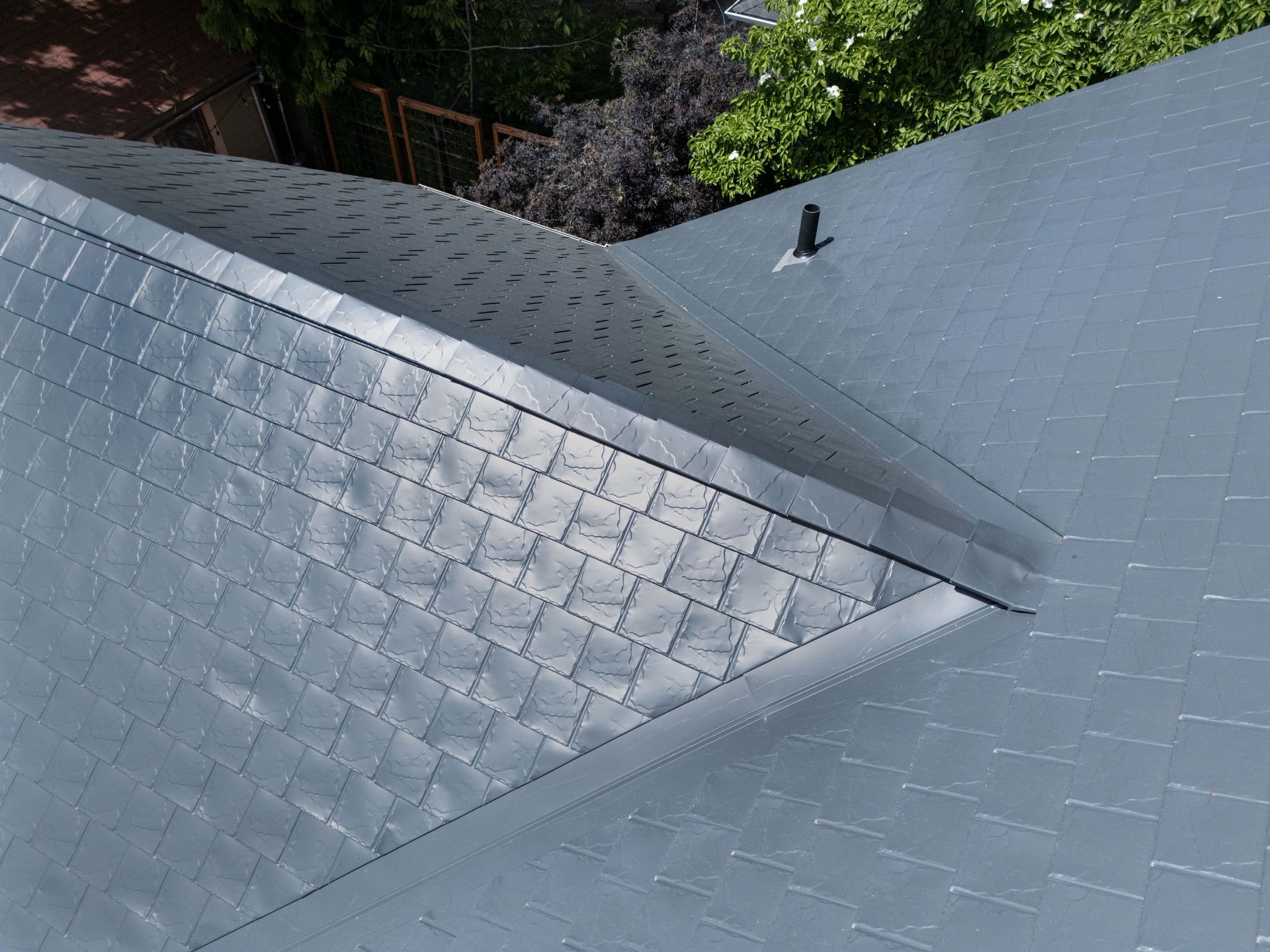 Close-up of Interlock Metal Roofing’s Deep Charcoal aluminum slate panels installed with precise detail and seamless ridge venting. Captured in Portland’s University Park, this durable, lightweight metal roof enhances the home’s resilience to rain, wind, and fire common to the Pacific Northwest.