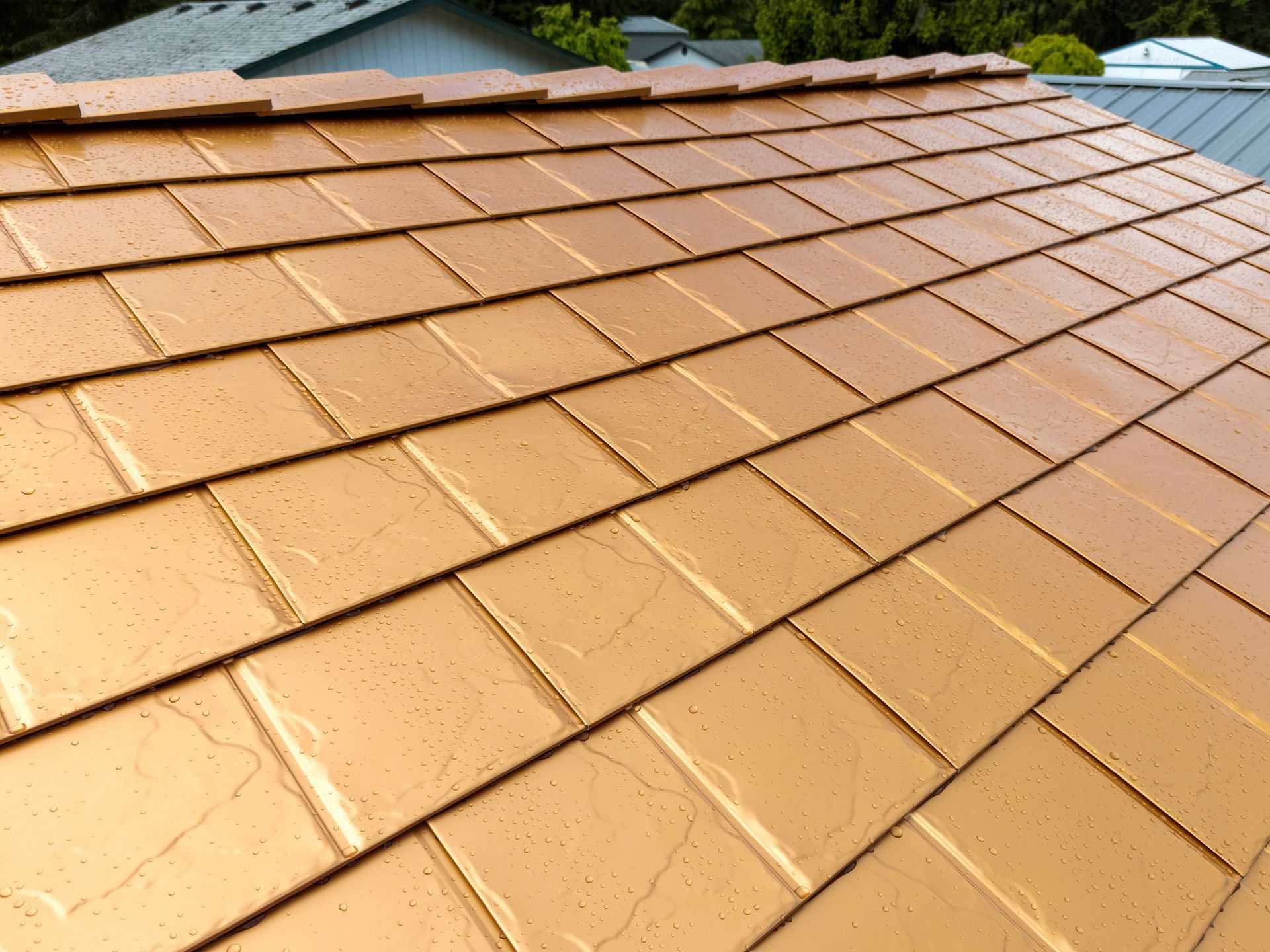 Close-up detail of Copper Penny aluminum slate roof shingles installed by Interlock Metal Roofing in Castle Rock, WA. The image highlights the embossed texture, seamless interlock design, and water-shedding capabilities under light rain, emphasizing the durability and premium finish of the heavy-gauge aluminum roofing system.