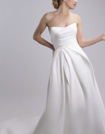 A woman is wearing a white strapless wedding dress