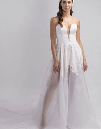 A woman is wearing a white wedding dress with a plunging neckline.