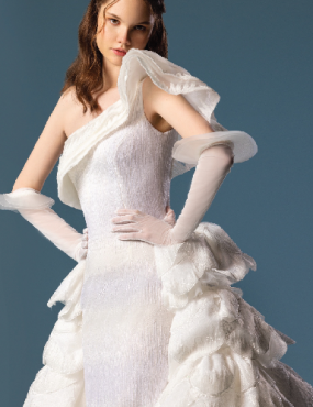 A woman is wearing a white dress and white gloves