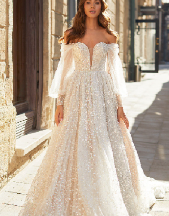A woman is wearing a white wedding dress with long sleeves.