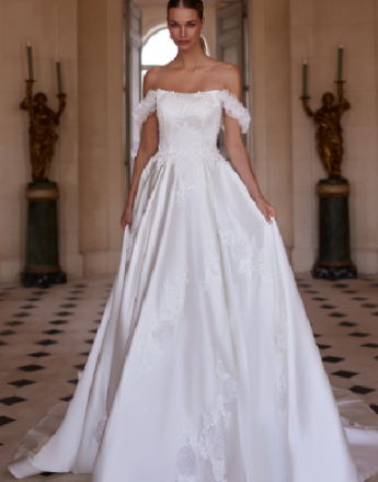 A woman in a white wedding dress is standing in a hallway