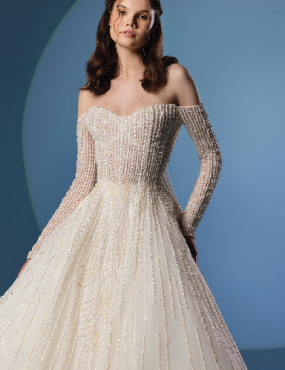 A woman is wearing a white wedding dress with long sleeves.