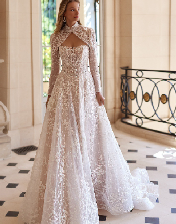 A woman is wearing a white lace wedding dress with long sleeves.