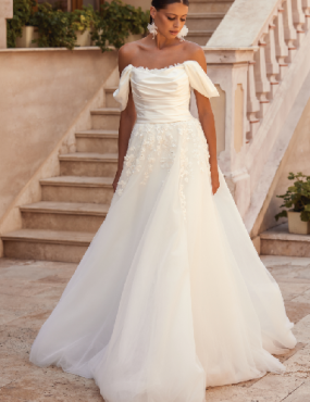 A woman in a white wedding dress is standing on stairs