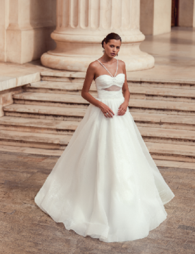A woman in a white wedding dress is standing on stairs