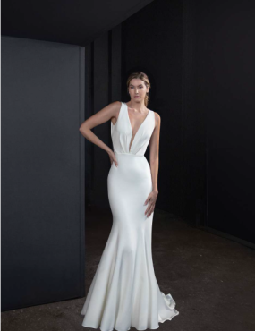 A woman is wearing a white dress with a plunging neckline