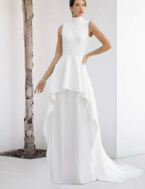 A woman in a white dress is standing next to a tree