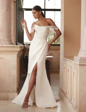 A woman in a white wedding dress with a high slit