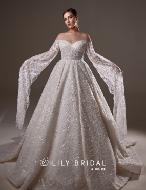 A woman is wearing a white wedding dress from lily bridal