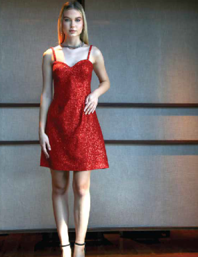 A woman in a red dress is standing in front of a wall