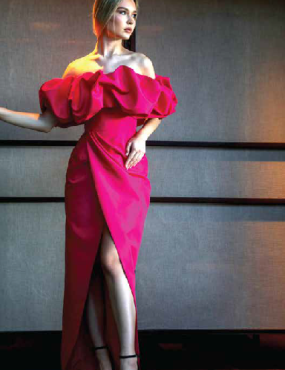 A woman in a long red dress with ruffles on the sleeves