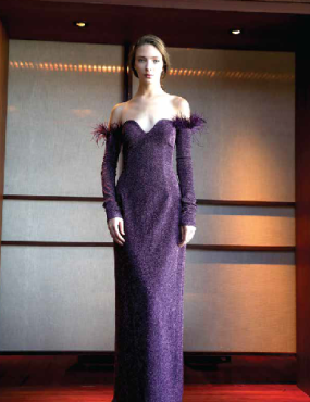 A woman in a long purple dress with feathers on the sleeves