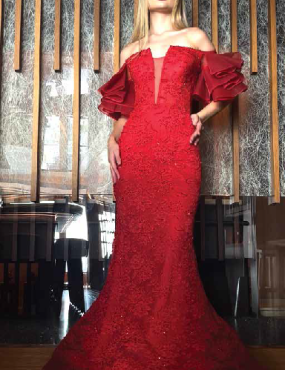 A woman in a long red dress with ruffled sleeves