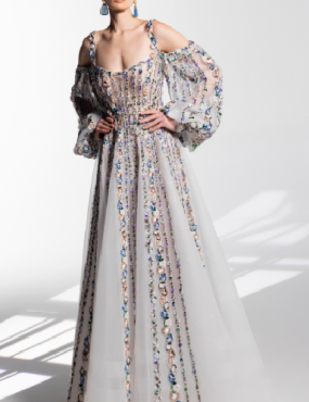 A woman is wearing a long white dress with balloon sleeves.