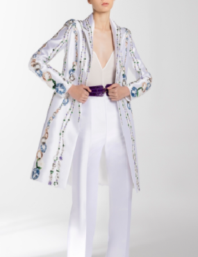 A woman is wearing a white coat and white pants