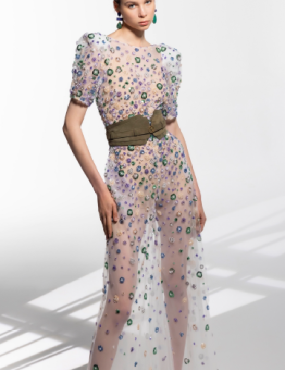 A woman is wearing a sheer dress with flowers on it