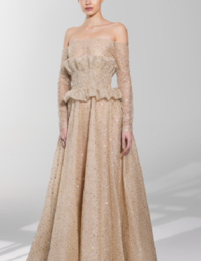 A woman is wearing a long beige dress with long sleeves