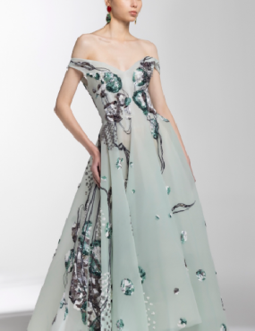 A woman is wearing a long dress with flowers on it