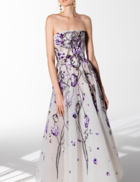 A woman is wearing a white dress with purple flowers on it