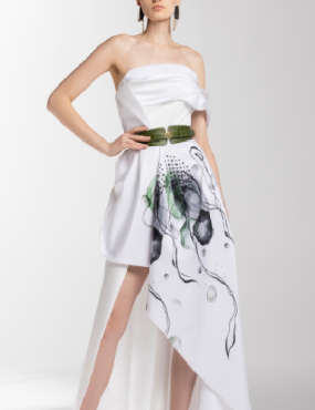 A woman is wearing a white dress with a green belt