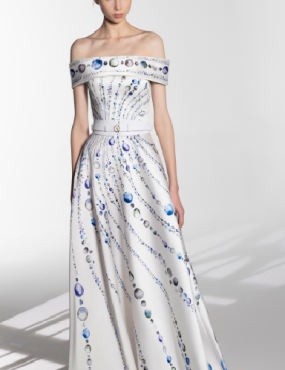 A woman is wearing a white off the shoulder dress